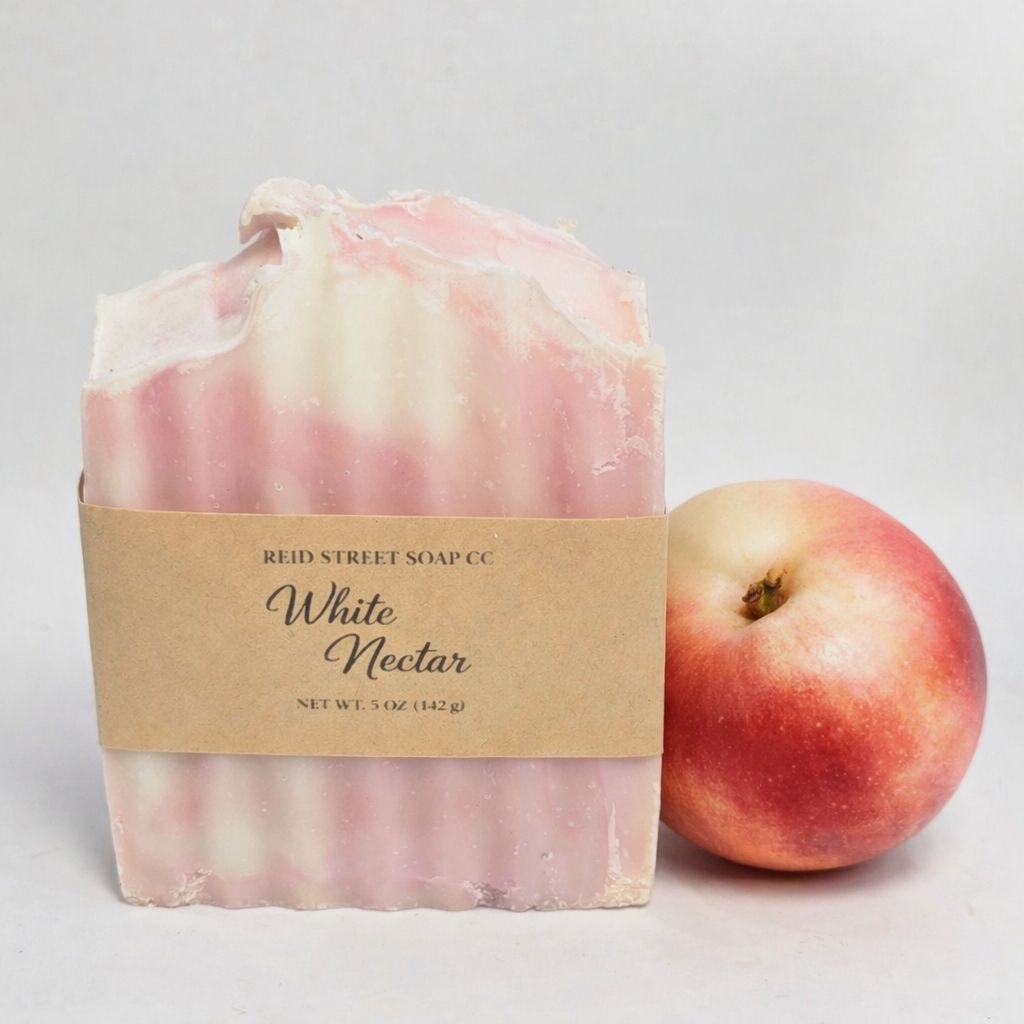 Bar of soap with 'Reid Street Soap Co' label next to a peach on a light gray background