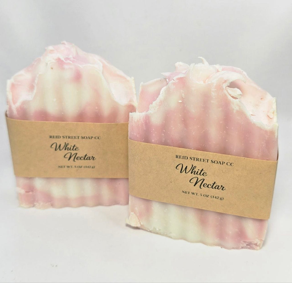 Two bars of 'White Nectar' soap from Reid Street Soap Co. on a light gray background.