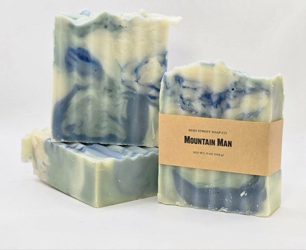 Three bars of soap with blue and white swirls, one bar has a 'Mountain Man' label.