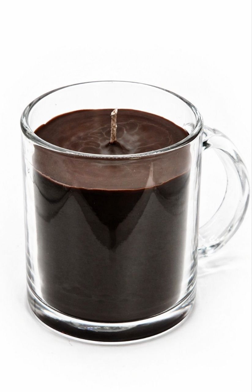 Candle in a glass mug with a handle on a white background