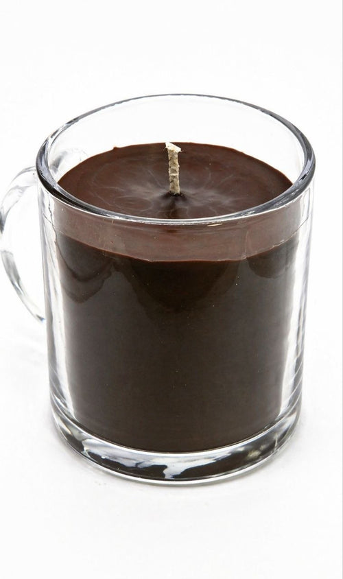 Candle in a clear glass mug on a white background