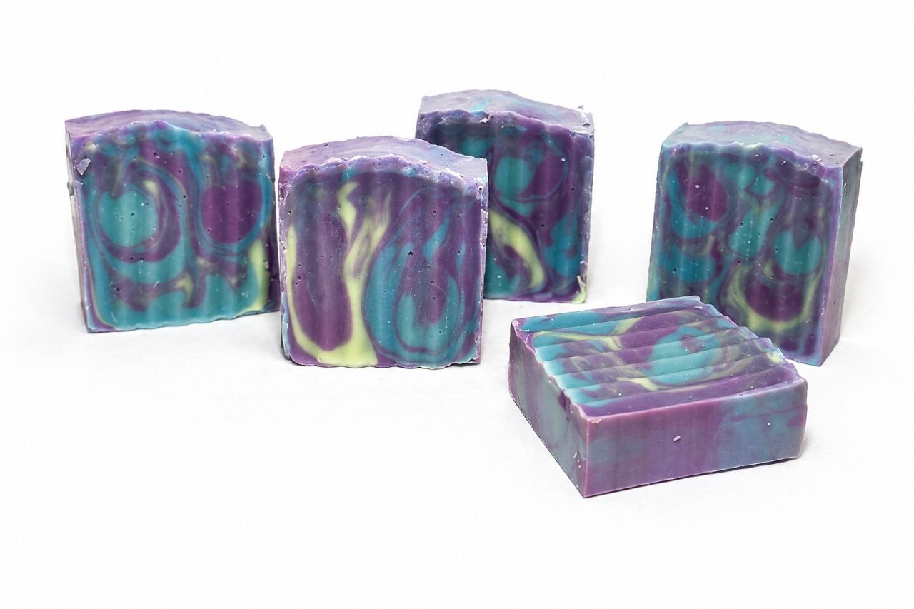 Five bars of colorful soap with a marbled pattern on a white background